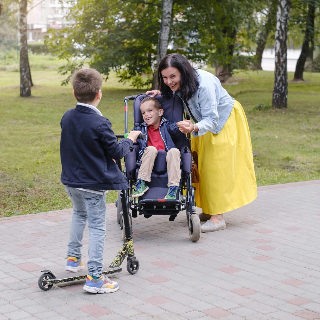 Family with child that has cerebral palsy on wheelchair with mother, brother