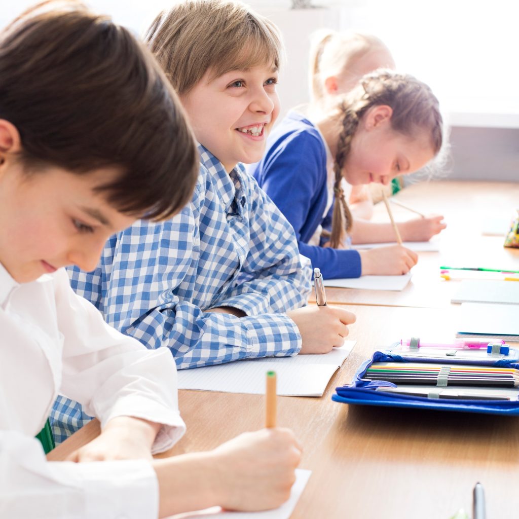 Happy kids writing an exam