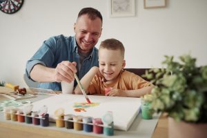 kid boy and dad painting together