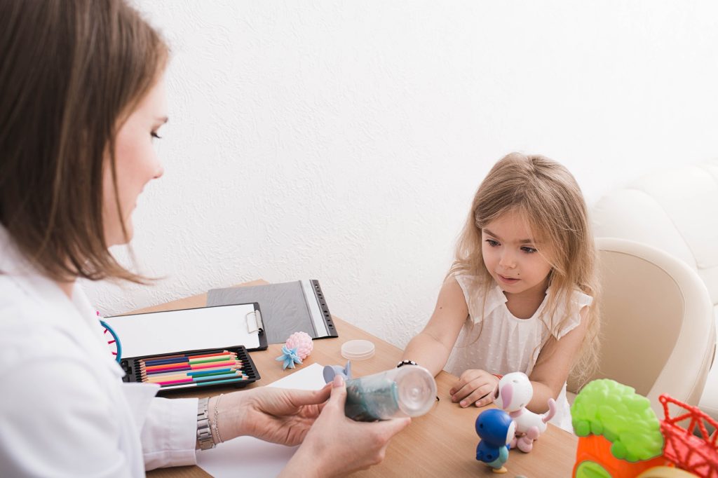 Cute little girl during play therapy at child psychologist's office