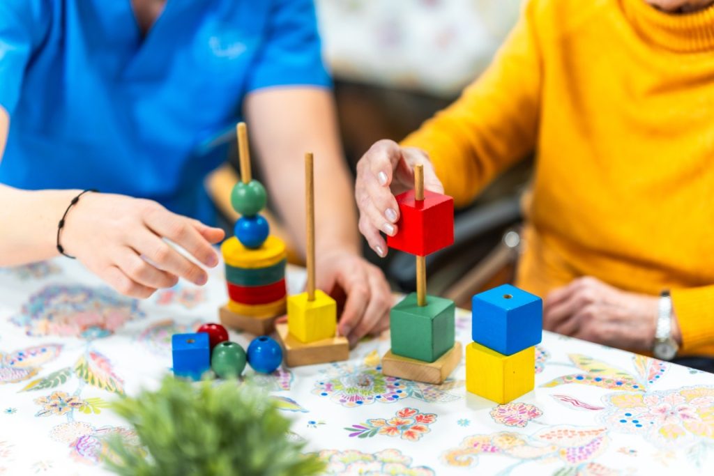 nurse assisting elderly woman playing with colorfu 2026 01 09 10 26 00 utc Medium