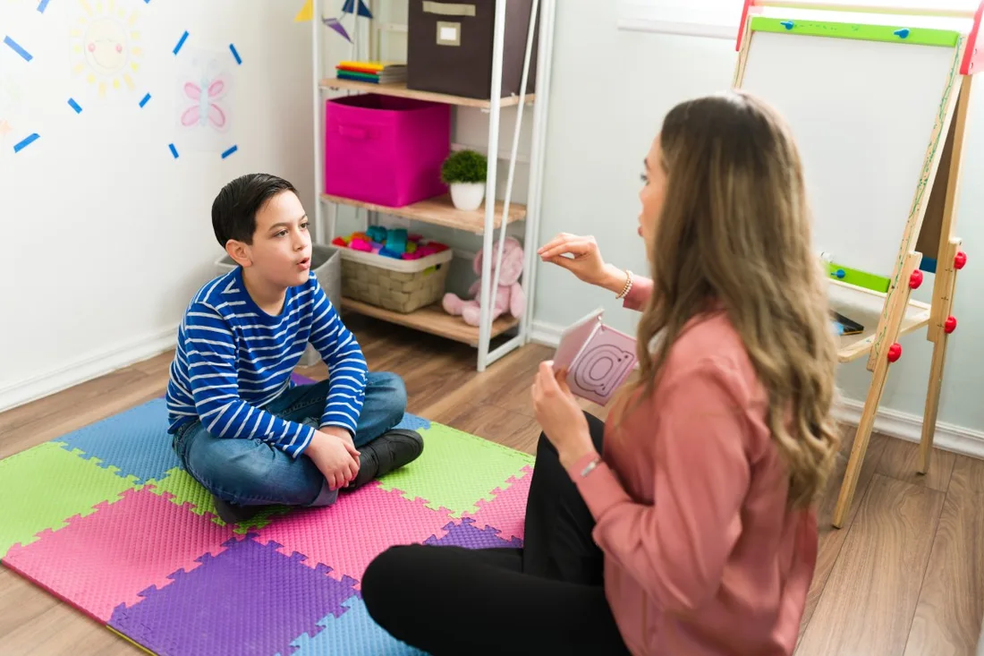 Behavior technician working one on one with a child on the floor during an early ABA therapy session in Miami
