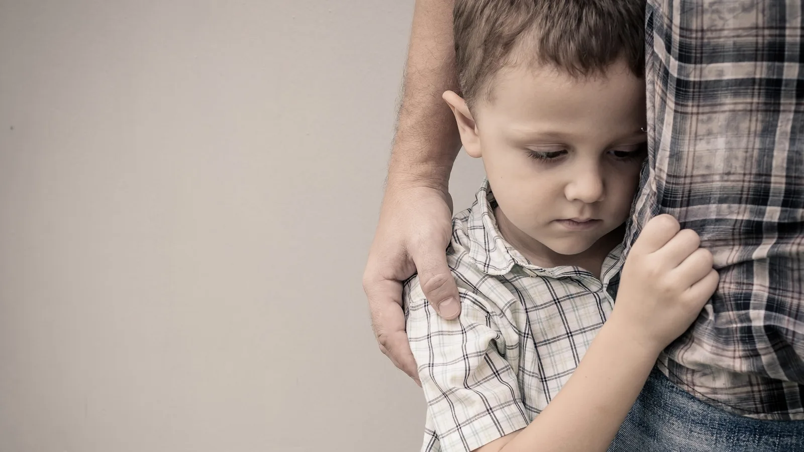 Young child holding on to a parent for comfort after becoming overwhelmed, a common moment for Miami families