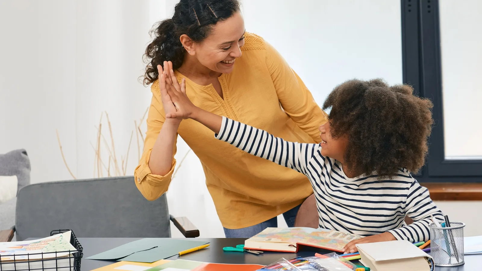 Behavior therapist and a young child sharing a high five during an early ABA therapy session in Miami